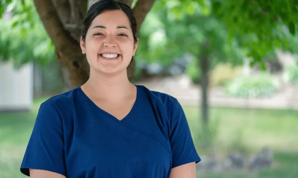 Happy nurse standing outside and smiling at camera